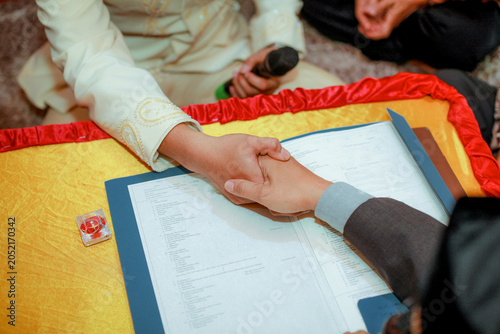 a solemn handshake during an Islamic marriage solemnization ceremony, known as ijab kabul, in Indonesia