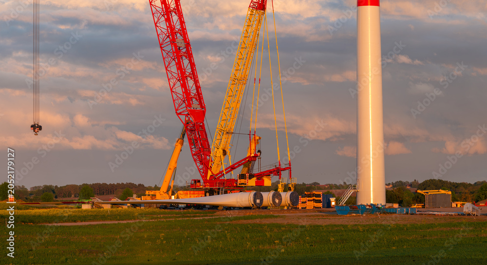 Naklejka premium Installation of wind turbines using a massive mobile crane in a spring field