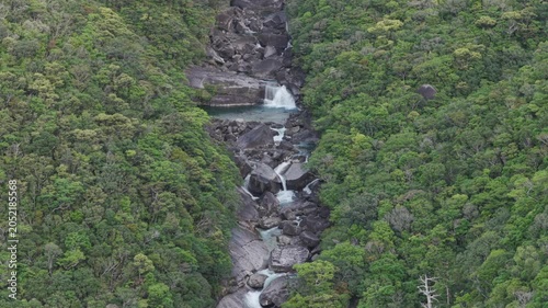 Flying over rocky stream and cascades in green forest - Yakushima, Japan
