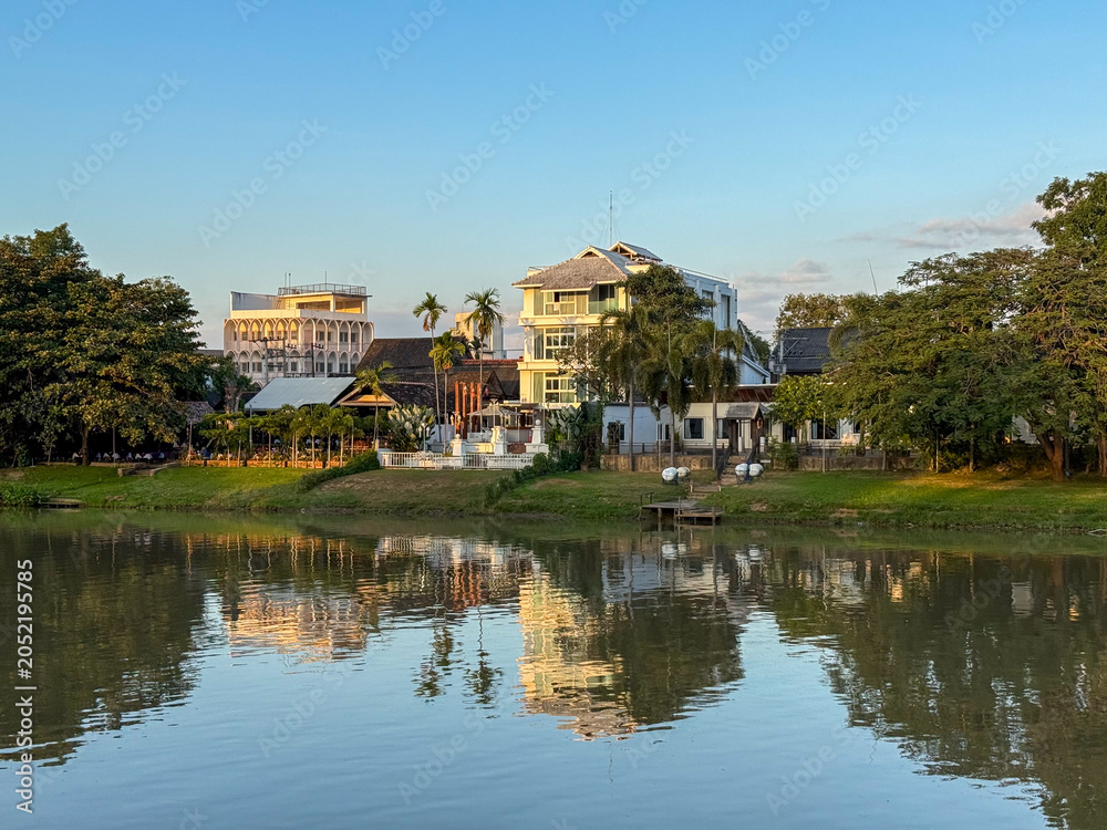 Fototapeta premium Riverside buildings reflecting in the water in Chiang Mai