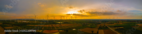 Landscape panorama of Many wind turbine at the fields at sunset