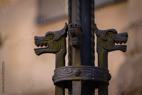 Fotografi Głowy metalowych smoków na latarni