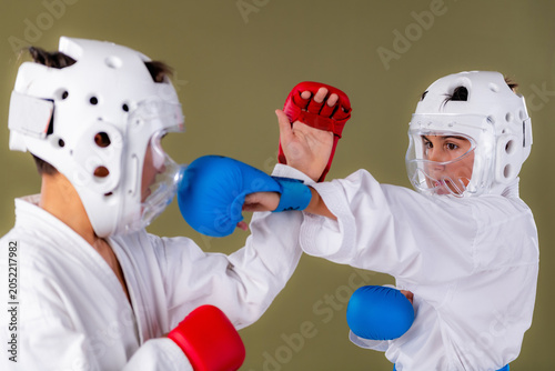 Photos Karate fighter delivers a blue gloved punch to the opponent's midsection while r