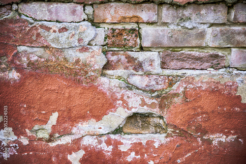 Tableau sur toile Decaying red wall with broken plaster close up