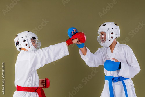 Tableau sur toile Karate athletes simultaneously throw punches at face level during a controlled sparring drill, demonstrating coordinated offensive timing and upper body striking technique in full protective gear