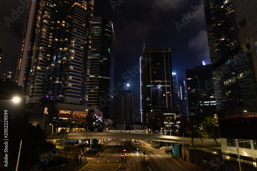Foto Night cityscape of Hong Kong's Admiralty district featuring illuminated skyscrapers, a multi-lane highway, and a pedestrian overpass stretching across Harcourt Road