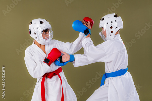 Photos Two young karate athletes engage in close range body contact during an intense sparring drill, both delivering simultaneous strikes to the torso and head in full protective martial arts gear