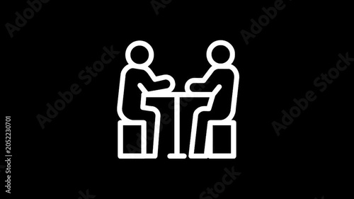 Two people sitting at a table, engaged in conversation or a meeting