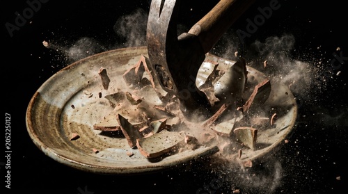 Flying clay shards and dust from broken pottery concept