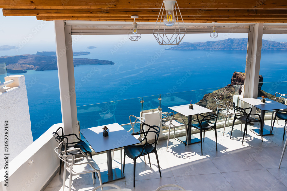 Fototapeta premium Santorini island, Greece. Cafe on the terrace with sea view at sunny day.