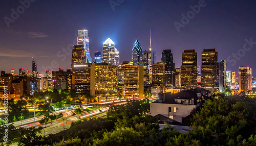 Illuminated cityscape at night, modern skyscrapers and glowing city lights, busy traffic below, lush green trees foreground
