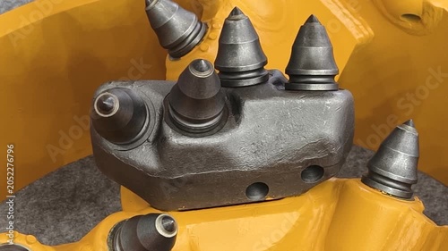 Heavy machinery part with drilling heads a construction setting during daytime, showing details