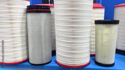 Different sizes of air filters displayed on a blue shelf in a storage area for industrial supplies