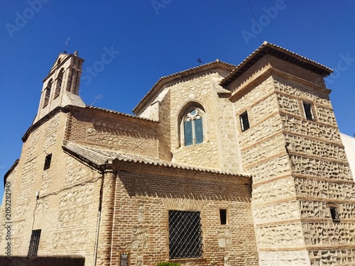 Edificio histórico de estilo mudéjar con fachada de ladrillo y piedra bajo un cielo azul