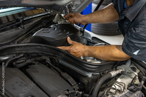 Auto mechanic working in repair shop garage. Vehicle maintenance and inspection service