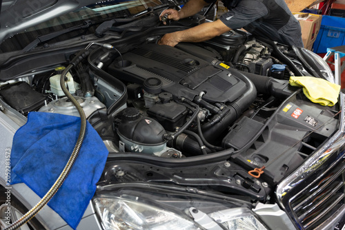 Auto mechanic working in repair shop garage. Vehicle maintenance and inspection service