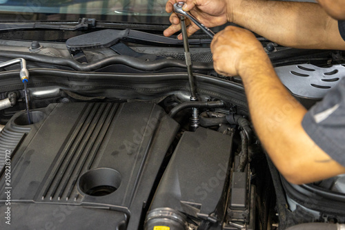 Auto mechanic working in repair shop garage. Vehicle maintenance and inspection service
