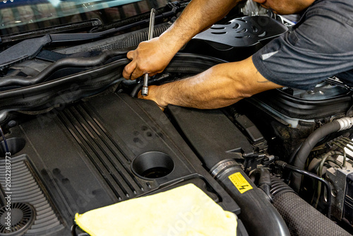 Auto mechanic working in repair shop garage. Vehicle maintenance and inspection service