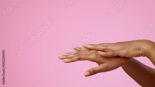 Focused Hands Of Black Woman Applying Moisturizing Cream To Skin With Care, Showcasing Skincare Routine At Home, In Cozy Setting. Unrecognizable, Emphasizing Self-care And Beauty Concept