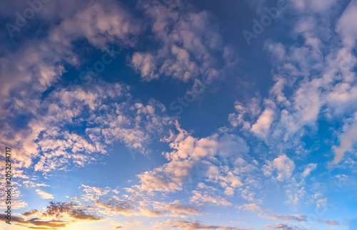 A dramatic sunset in evening colors of orange, red, and blue. A breathtaking picture celestial interplay of warm and cool tones. The setting sun gives yellow gleam horizon. Big copy space for my text.
