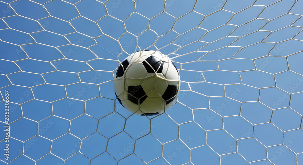 Fototapeta premium Soccer ball caught in white net against clear blue sky goal sport