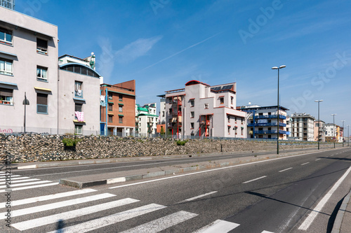 Obraz na płótnie Strada cittadina con edifici residenziali moderni, balconi e attraversamento pedonale in una giornata luminosa
