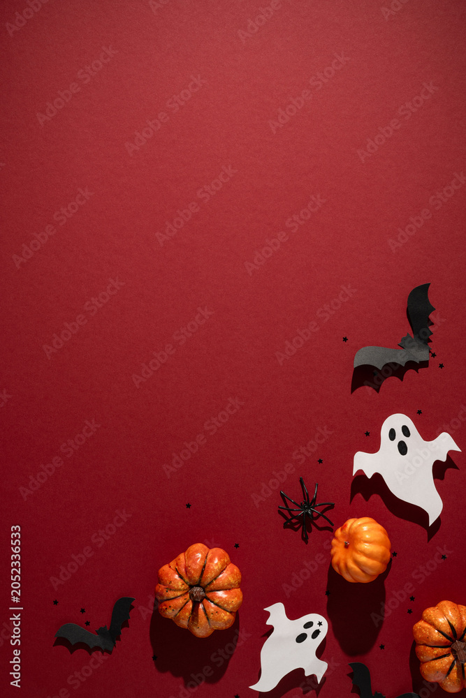 Obraz premium Autumn Halloween arrangement with pumpkin ghost bat and spider on vertical red textured background