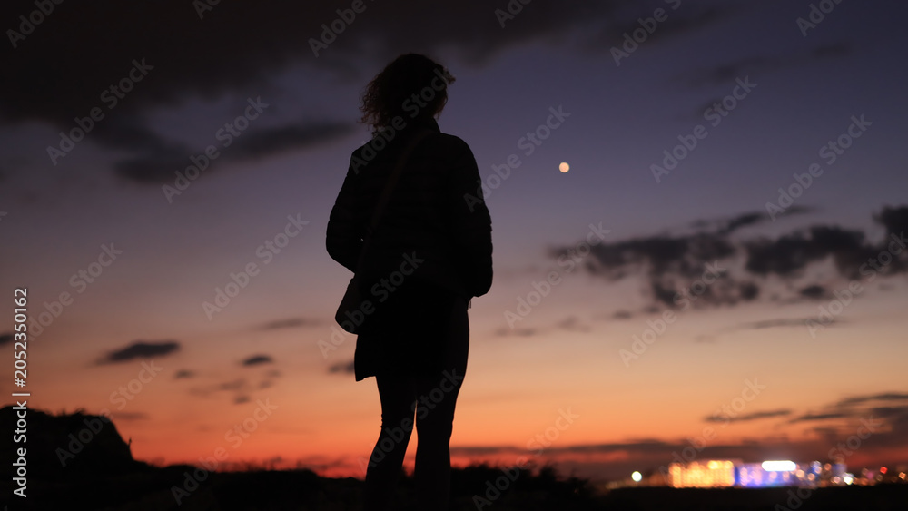 Obraz premium Silhouette of a woman looking at blue hour morning - evening skies with planet Venus.