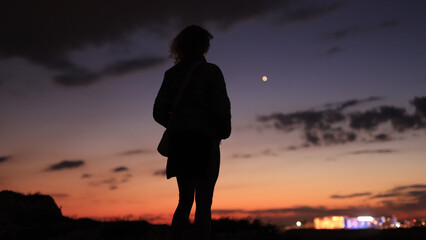 Silhouette of a woman looking at blue hour morning - evening skies with planet Venus.