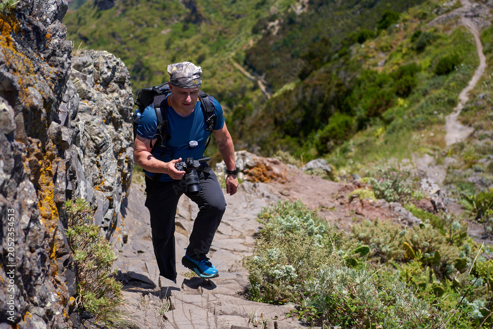 Fototapeta premium Hiker climbing rocky Anaga ridge trail