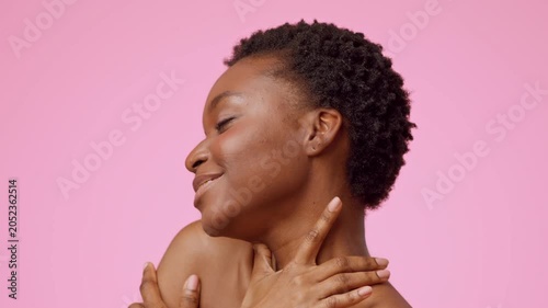 Joyful Black Woman Smiling With Natural Hair, Embracing Herself While Posing In Front Of A Pink Background. Showcasing Confidence And Self- In A Bright, Cheerful Setting. Beauty Concept