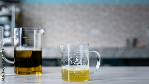 Canvas Print Yellow Liquid in Laboratory Beaker on Modern Lab Table