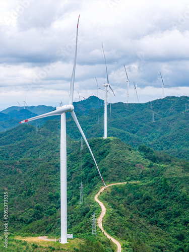 Aerial view of wind turbines on green mountain ridges