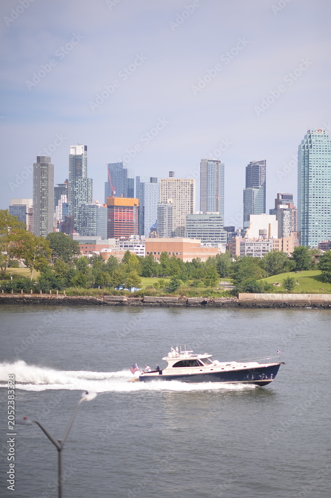 Fototapeta premium Riverfront city skyline with speedboat