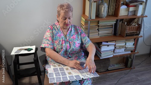 Elderly senior woman playing a card game of solitaire on board.