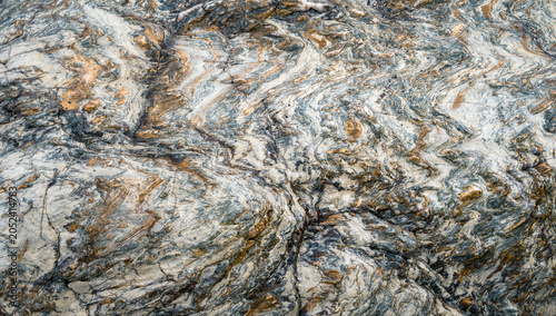 Konstfotografi Wavy striations in a quartzitic rock interspersed with golden veins of pyrite