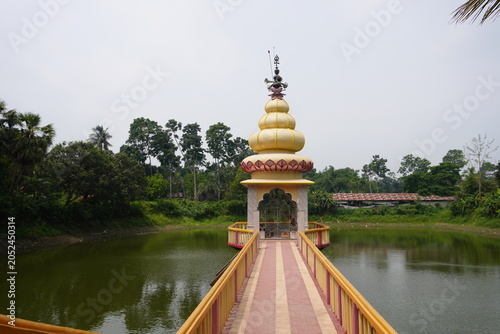 Temple with Golden Dome and Red Decorations on Walkway over Water