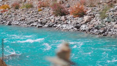 Beautiful blue river flowing in the Himalayas. Defocused stone tower near flowing Zanskar River in Ladakh, India. River seen from Phugtal monastery. Nature, environment and climate change concept.