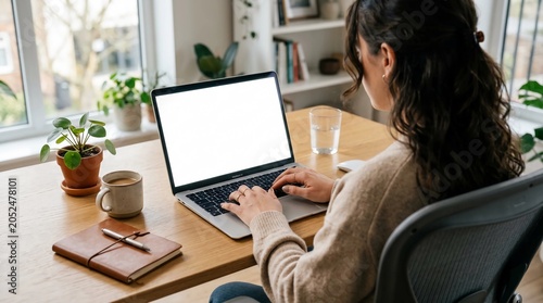 Professionals reviewing documents on laptop at office desk with notebook and coffee