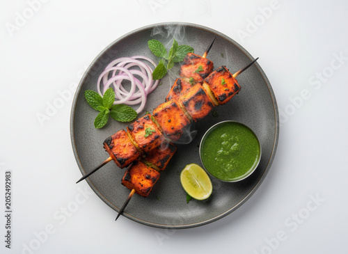 Smoky paneer tikka platter isolated on white background for authentic tandoori indian starter