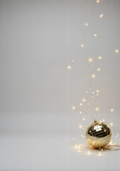 Golden disco ball with fairy lights on neutral background for New Year  