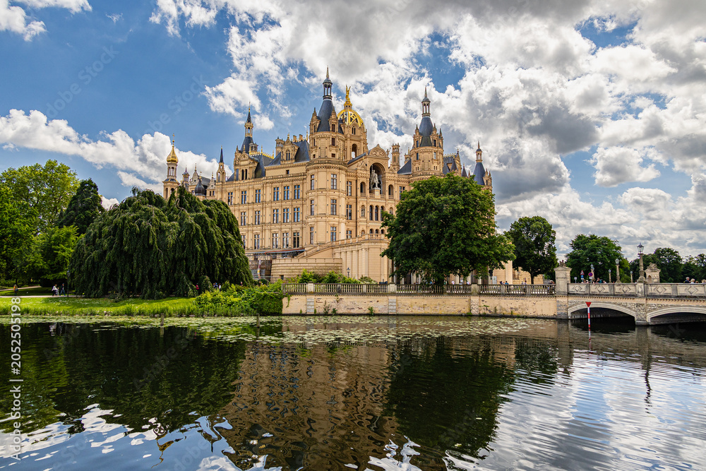 Obraz premium Schwerin Palace with Stone Bridge and Water Reflection in Mecklenburg