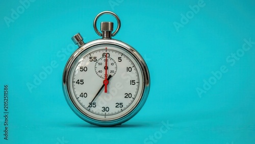 A close-up view of a stopwatch on a teal background shows time passing quickly.