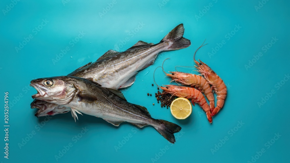 Obraz premium Fresh seafood arrangement with fish shrimp and lemon on blue