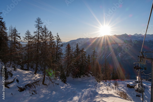Photography Sunrise over the Rhone Valley with snow-covered mountains, forested slopes and a