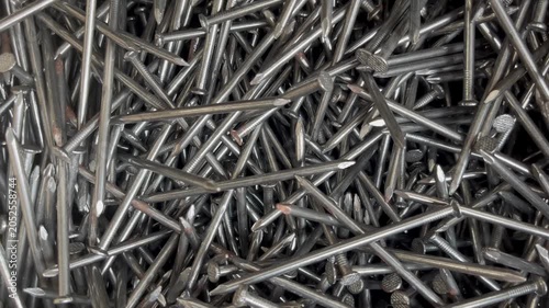 A messy heap of shiny steel wire nails for woodworking. Macrophotography of industrial fasteners and metal hardware equipment 