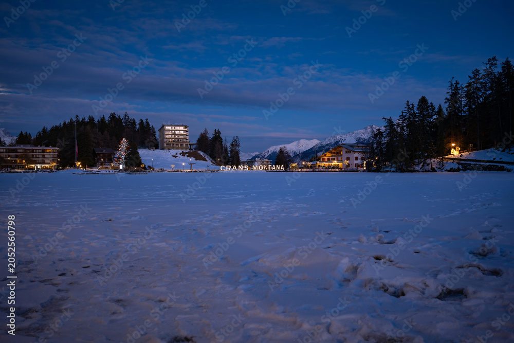 Obraz premium Scenic view of frozen and snow covered Etang Grenon (Lac Grenon) with illuminated lettering 