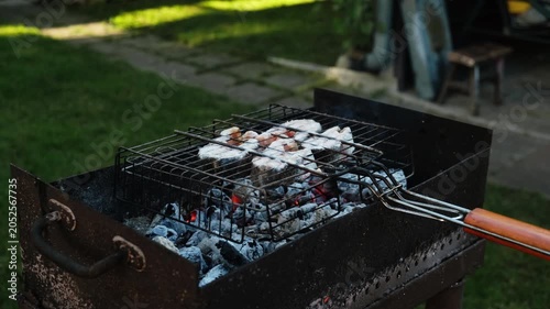 Man grilling steaks of salmon fish in backyard. Summer weekend activity, barbecue, cookout.