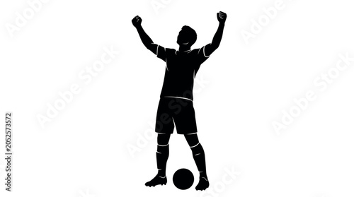Silhouette of a triumphant soccer player celebrating with arms raised
