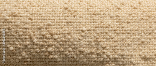 Macro view of beige bouclé fabric texture background with soft lighting